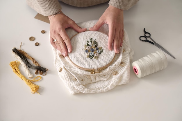 haftujące dłonie przy tamborku